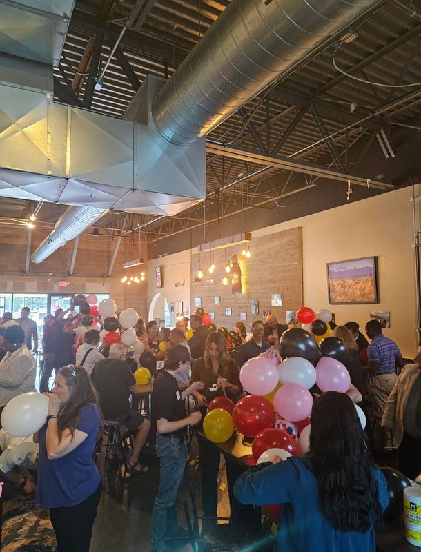 A packed room racing to build balloon towers at Next Level Networking