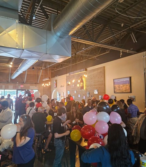 A packed room racing to build balloon towers at Next Level Networking