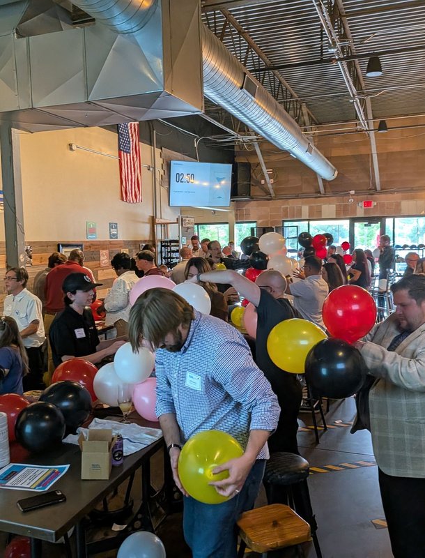 Teams blowing up balloons for the balloon tower challenge