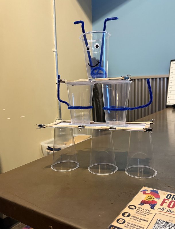 A googly-eyed tower of plastic cups and pipe cleaners from the Connection Tower Challenge