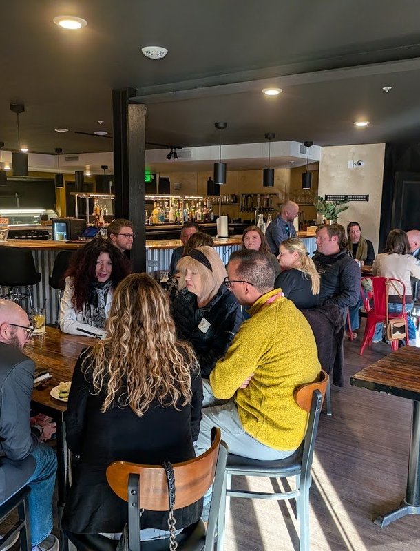 A full room of members at tables during an NIA meeting