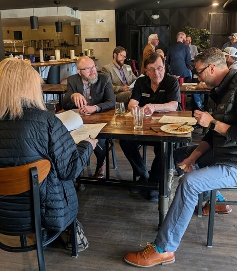 Members talking over notes at a meeting table