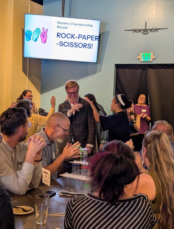 Guests mid-throw during the Rock Paper Scissors championship round