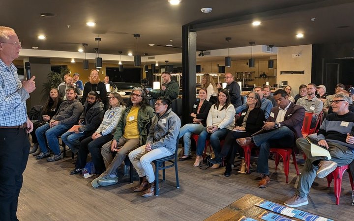 A speaker addressing a full room at an NIA Business Boost event in Colorado Springs