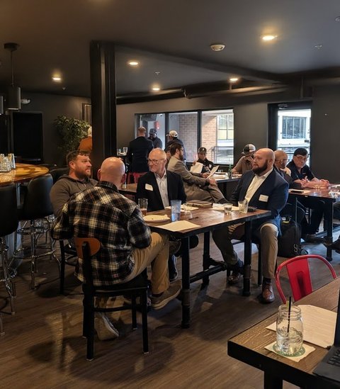 Members seated at long tables during a meeting