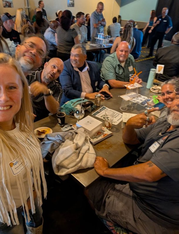 A guest grabbing a selfie with a grinning table at Next Level Networking