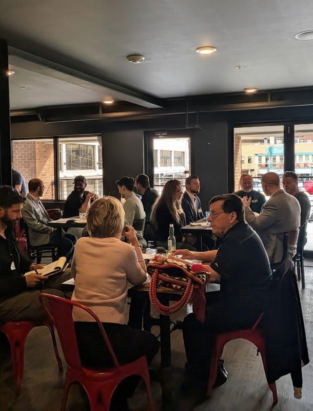 Members seated at long tables at an NIA Colorado Springs meeting
