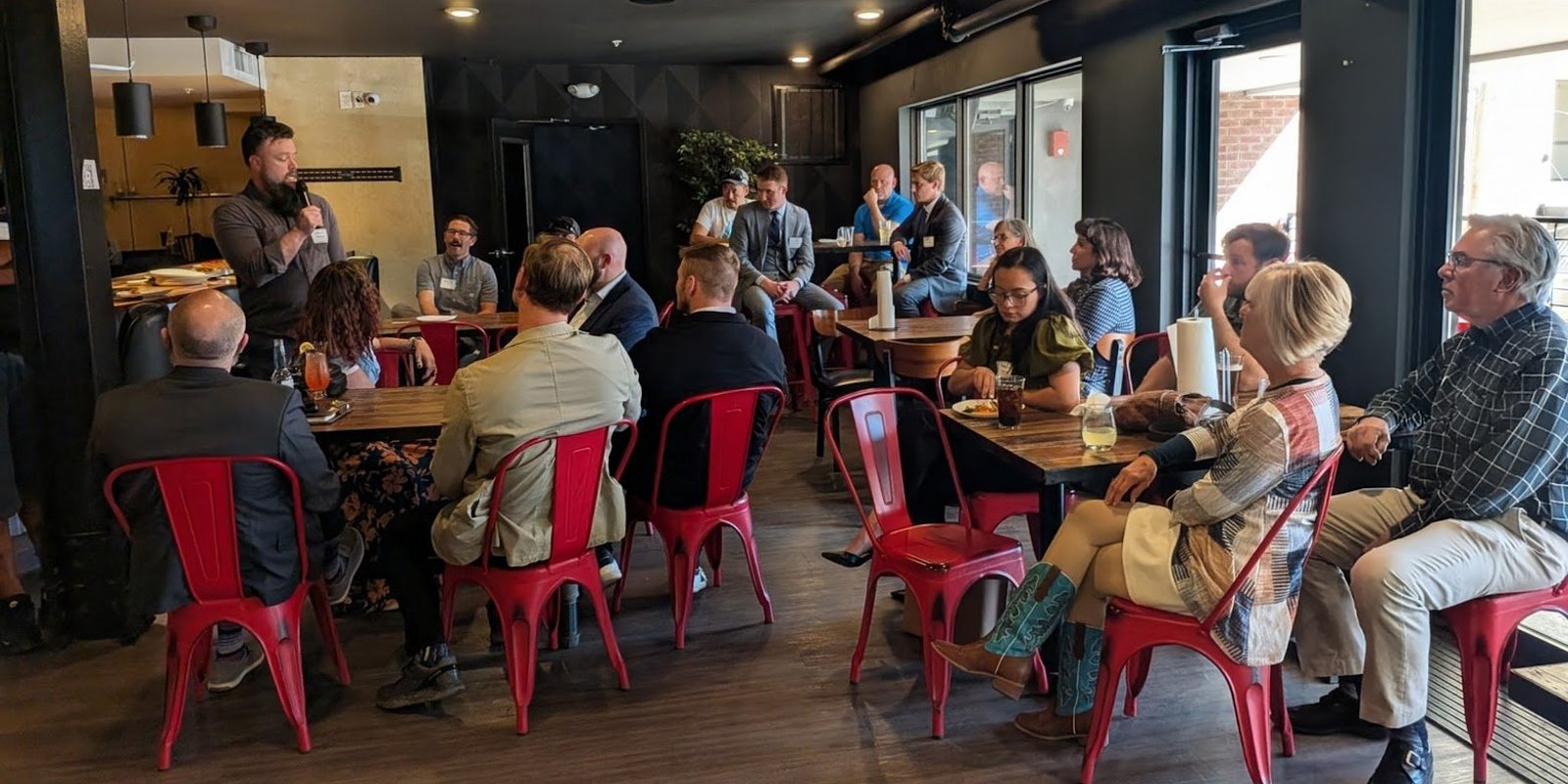 A full room of NIA Colorado Springs members at tables during a monthly meeting