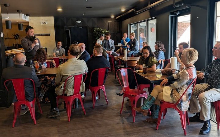 A full room of NIA Colorado Springs members at tables during a monthly meeting