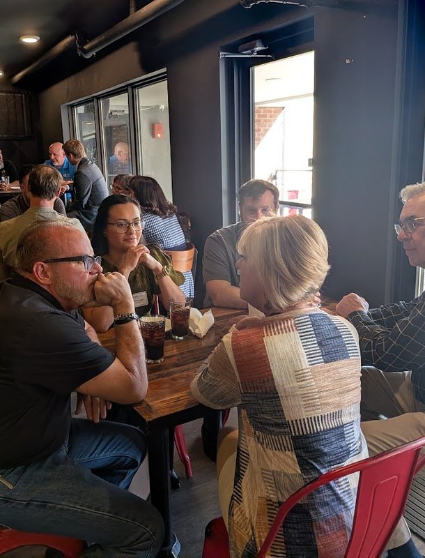Members talking across the table at a monthly meeting