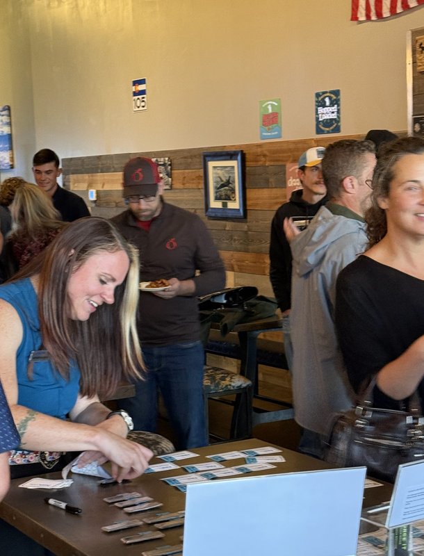 A host laughing at the welcome table as guests arrive