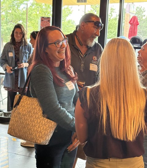 Guests sharing a laugh by the windows at 105 West Brewing