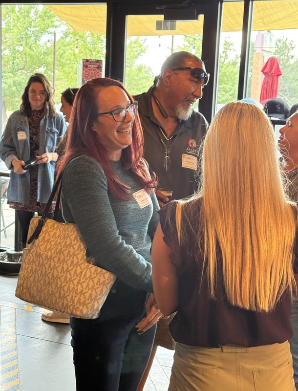 Guests sharing a laugh by the windows at 105 West Brewing