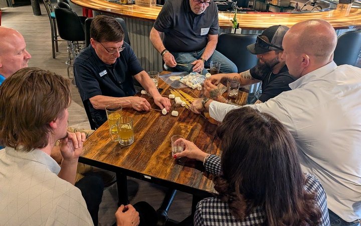 NIA Colorado Springs members talking across a table at a monthly member meeting