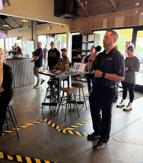 A host welcoming the room on the microphone
