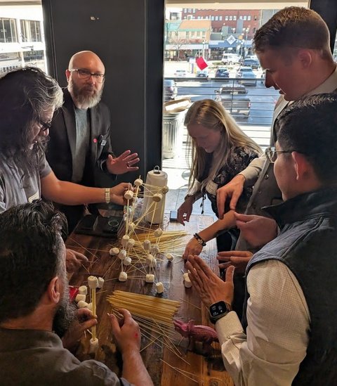 Members working together on a team challenge by the windows downtown