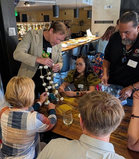 Members watching a marshmallow tower take shape