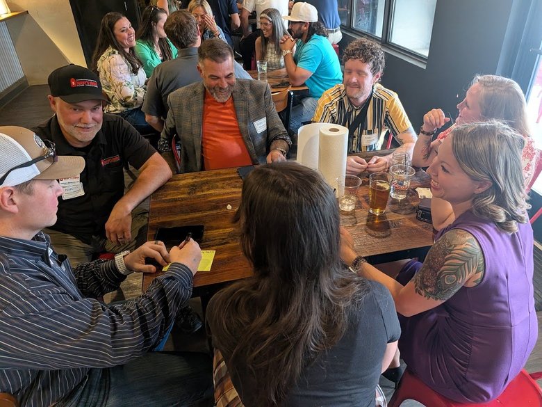 NIA Colorado Springs members laughing and talking around a table at a monthly meeting