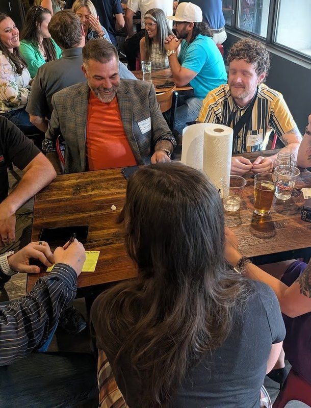 NIA members laughing around a table at a monthly meeting