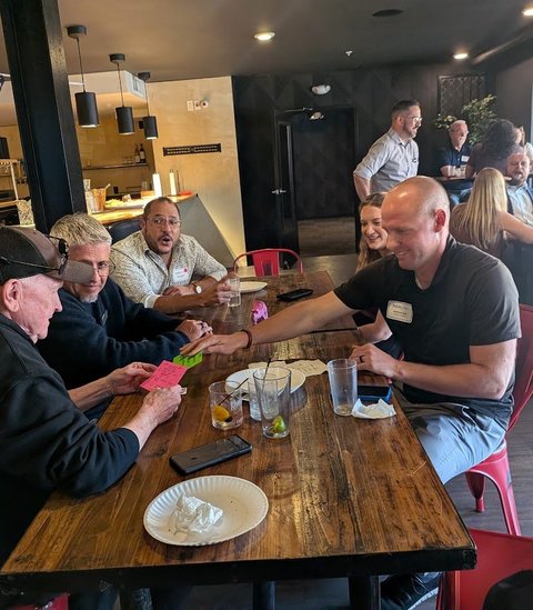 Members swapping cards across the table at an NIA meeting