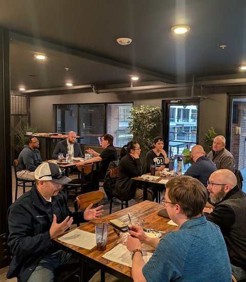 Members at tables near the patio doors