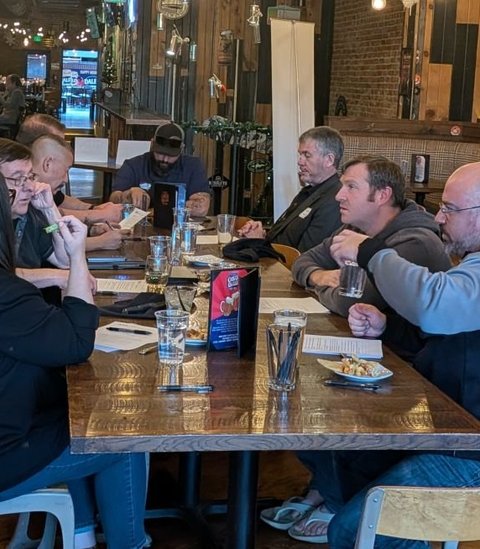 Members leaning in to talk across a table
