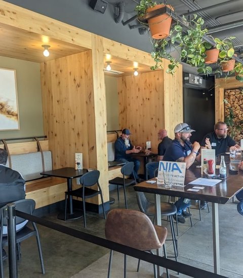 An NIA meeting in a bright, wood-paneled restaurant with the NIA sign on the table